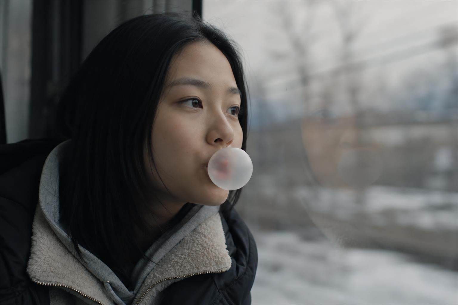 defector film Image showing the article's key context - The first poster shows Hye Seon blowing bubble gum, accompanied by th...