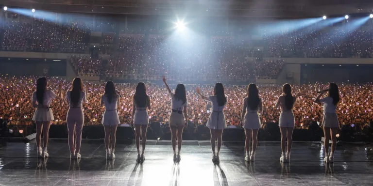 AI-generated editorial image representing a K-pop group reunion concert with bright stage lights and cheering fans