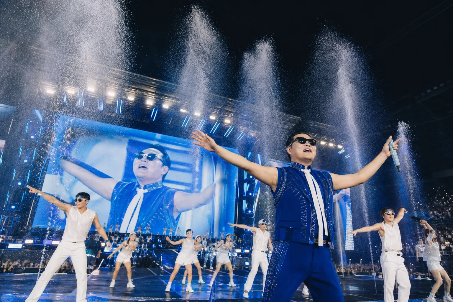 Large Korean concert stage with water effects and bright lights during a summer tour