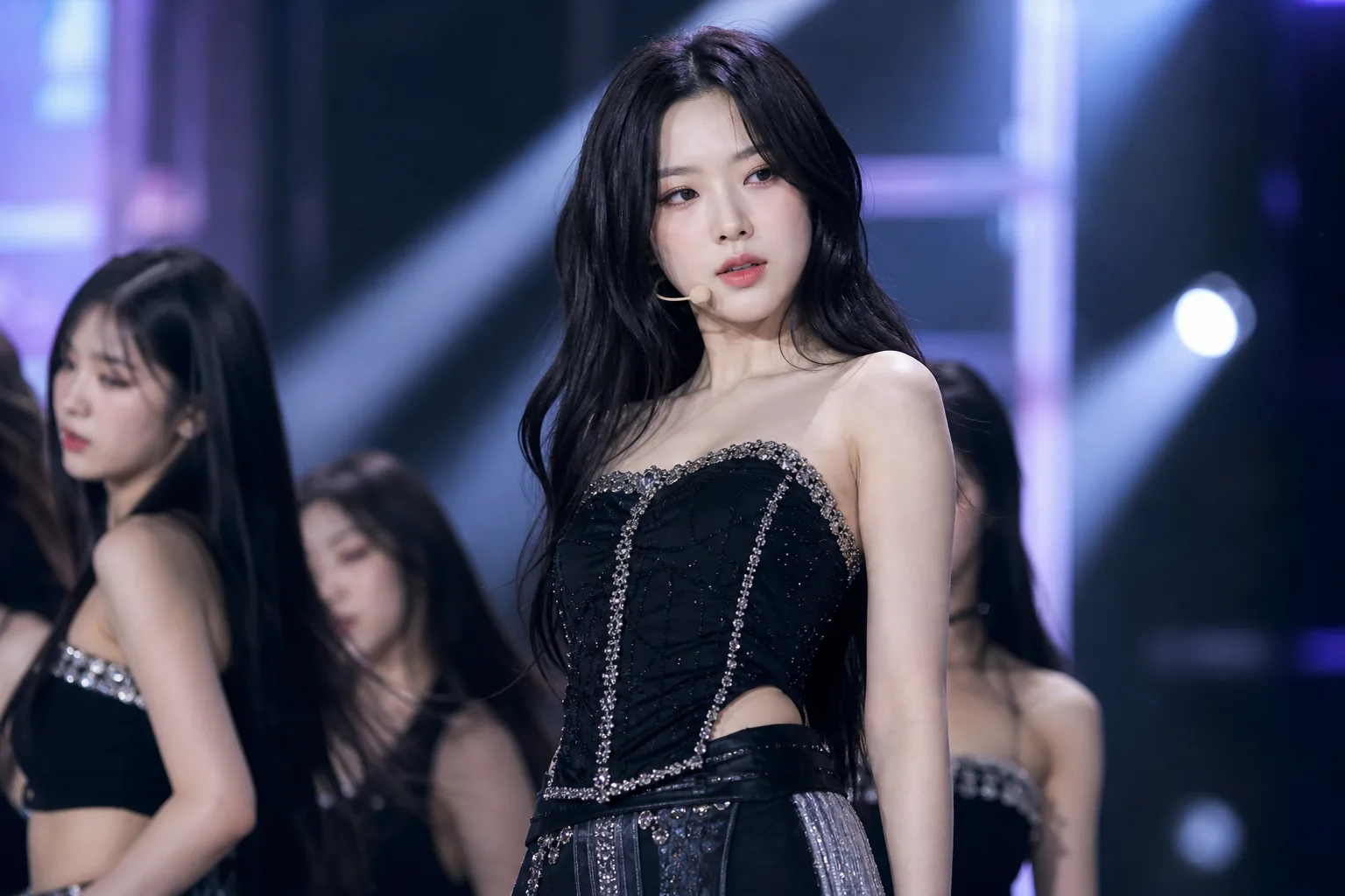 K-pop showcase stage atmosphere as fans discuss an idol's appearance