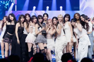 K-pop stage lights representing LE SSERAFIM ILLIT and KATSEYE winning on M Countdown