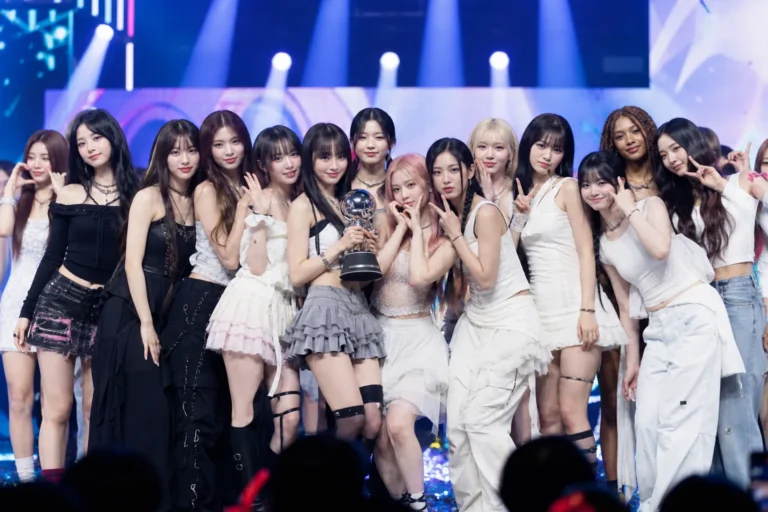 K-pop stage lights representing LE SSERAFIM ILLIT and KATSEYE winning on M Countdown