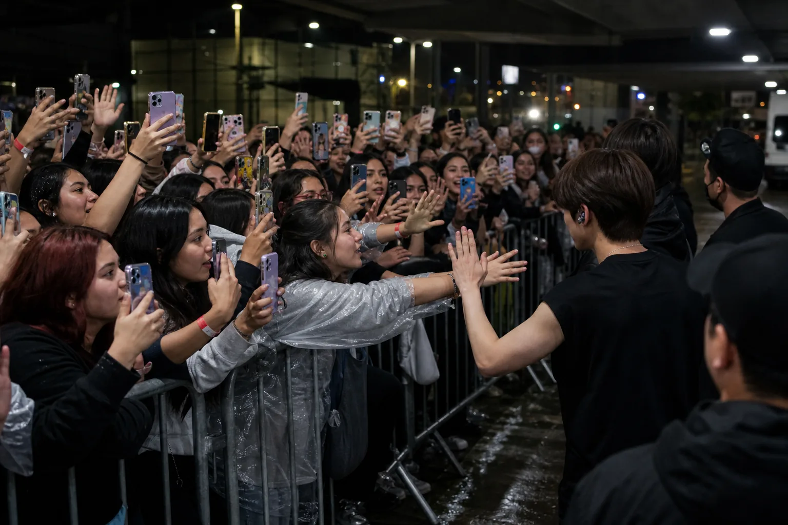 Fans waiting near a concert send-off barrier after a K-pop show