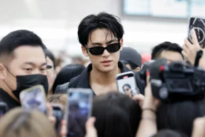 Crowded airport scene symbolizing concerns over K-pop idol boundaries