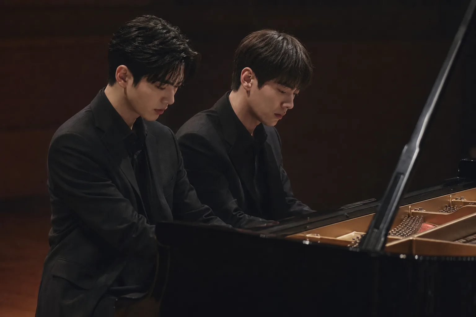 Two young pianists practicing a four hands duet in a dramatic rehearsal room