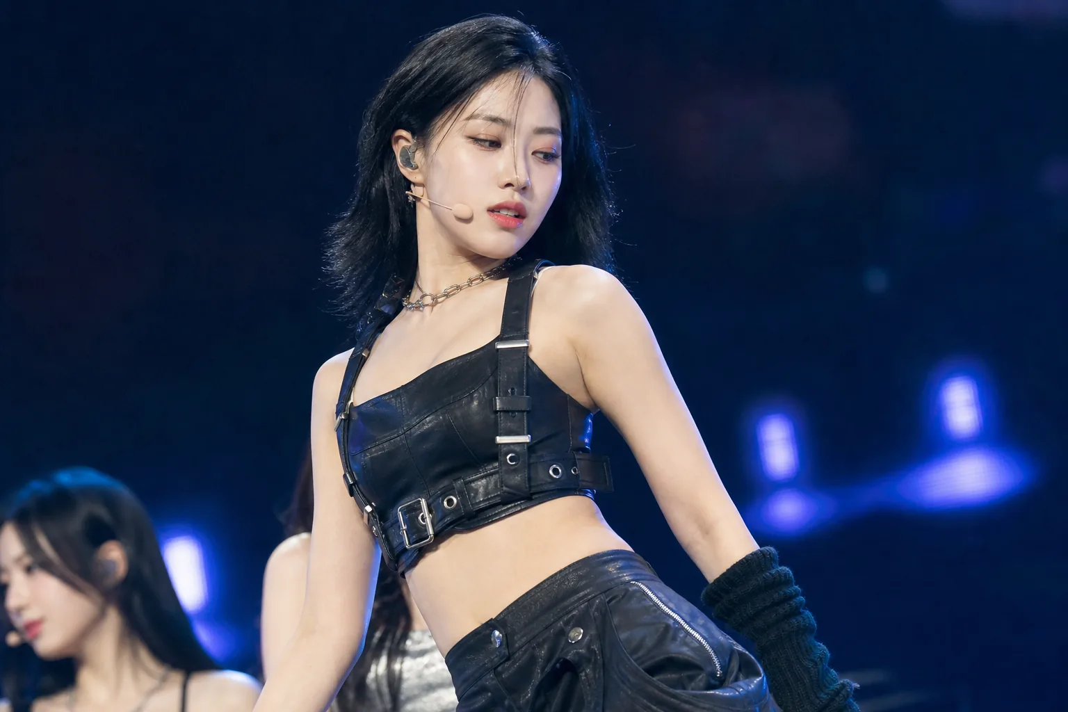 Social media screens and concert crowd symbolizing online debate over K-pop idol scrutiny