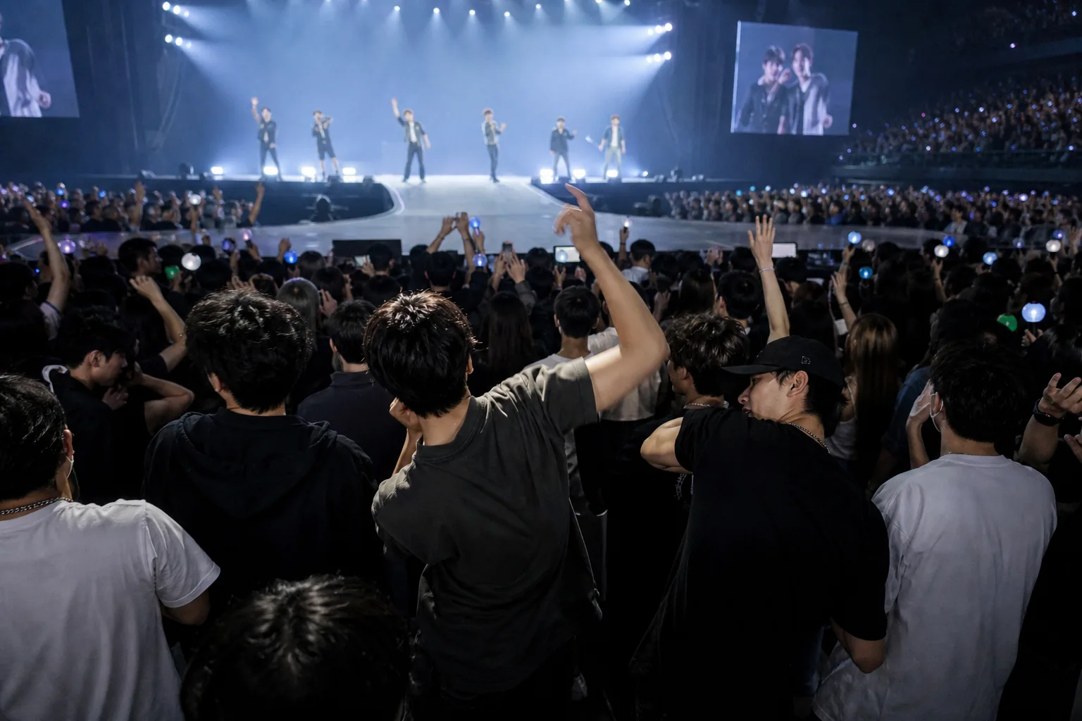 K-pop concert standing section with fans reacting to a live stage