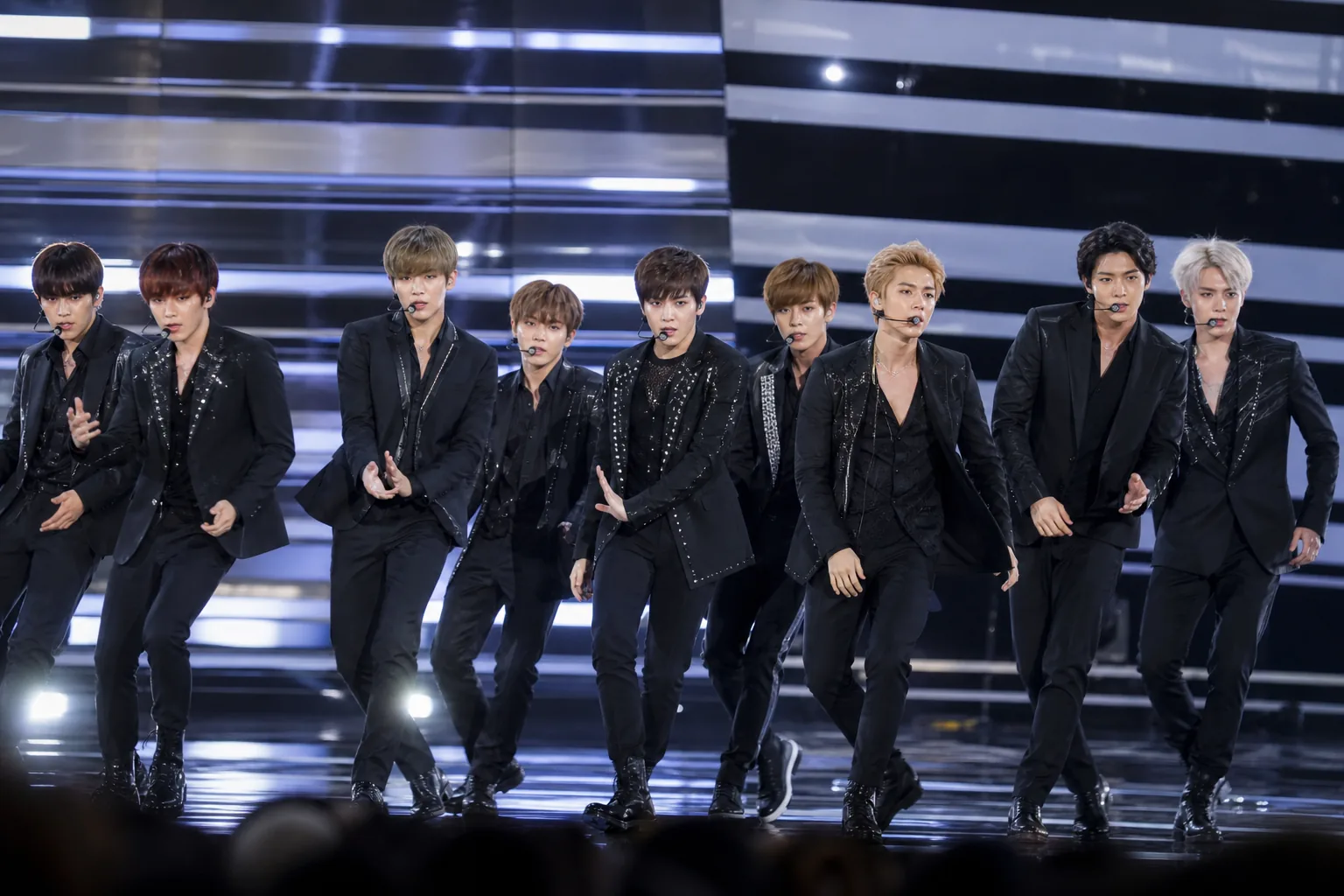 K-pop idol schedule board and concert lights symbolizing intense promotion workloads