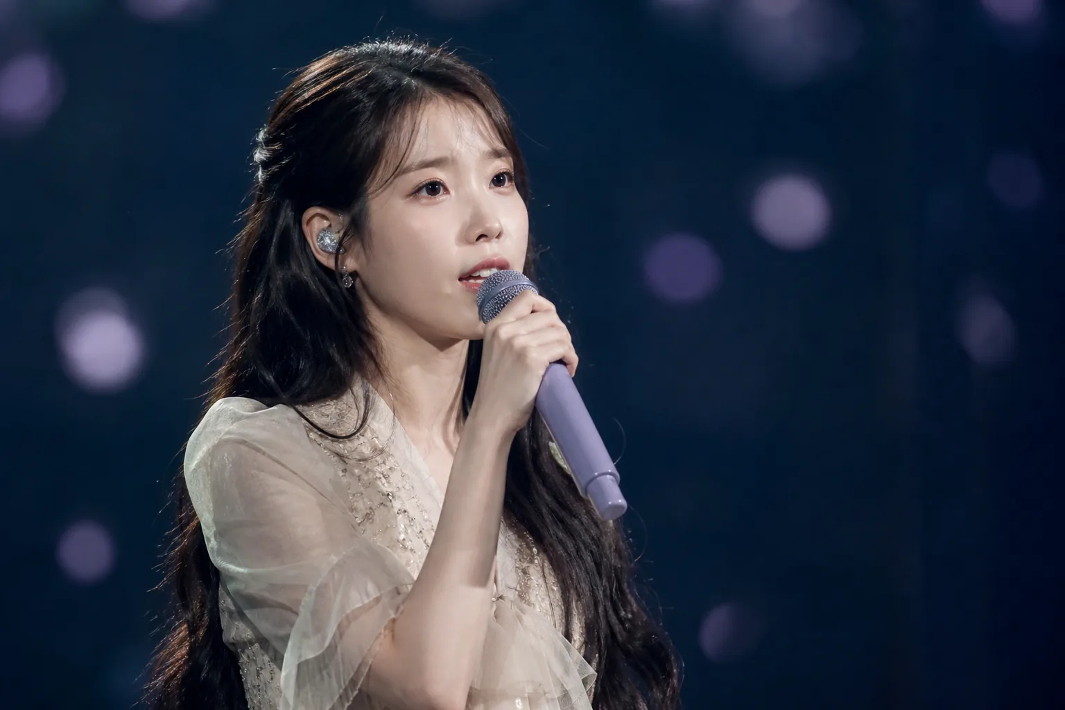 Quiet concert stage with microphone representing IU Goyang concert cancellation