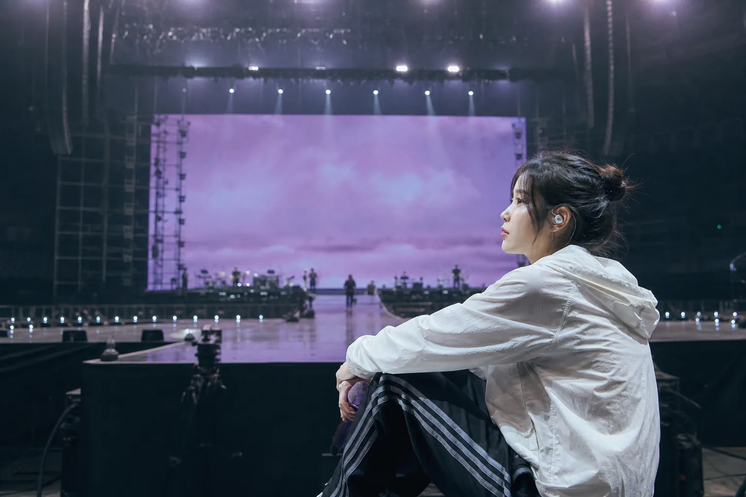 Concert microphone and stage lights symbolizing IU delaying live performances for health reasons