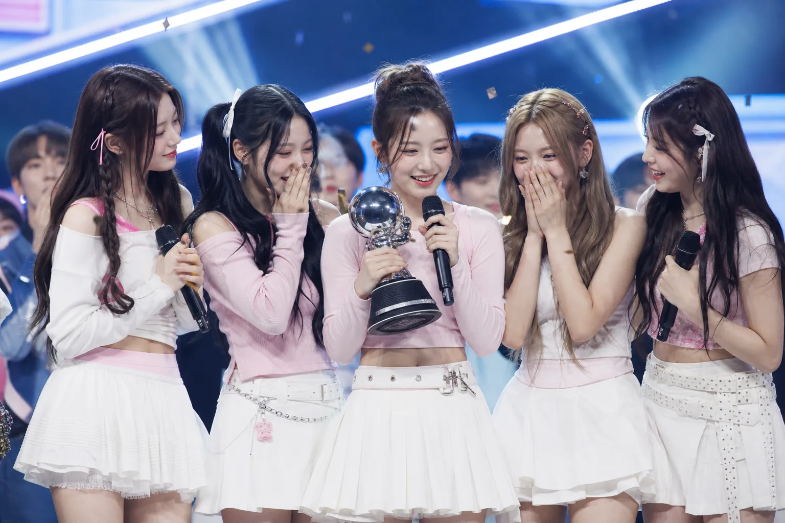 K-pop group celebrating a televised music show trophy