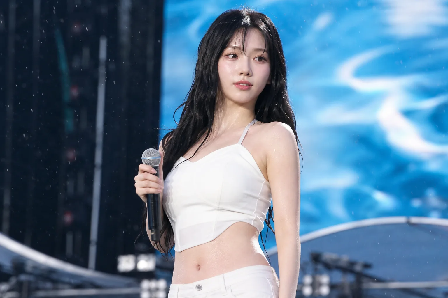 Fans watching a Korean entertainment festival performance under bright summer lights
