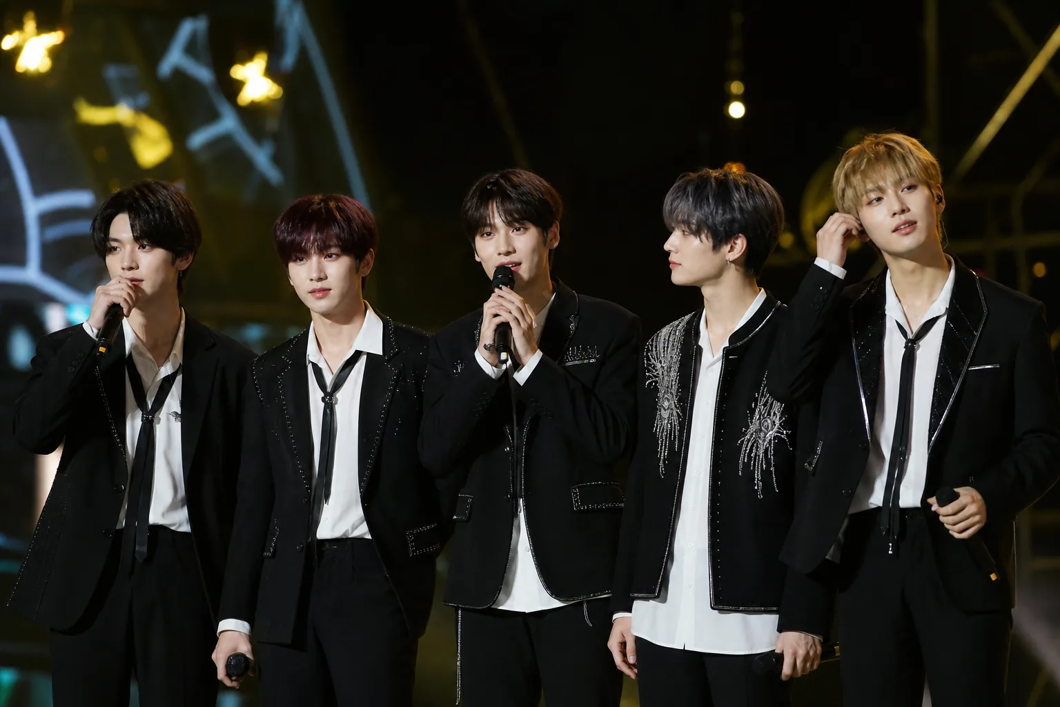 K-pop award show encore stage with bright lights and microphones