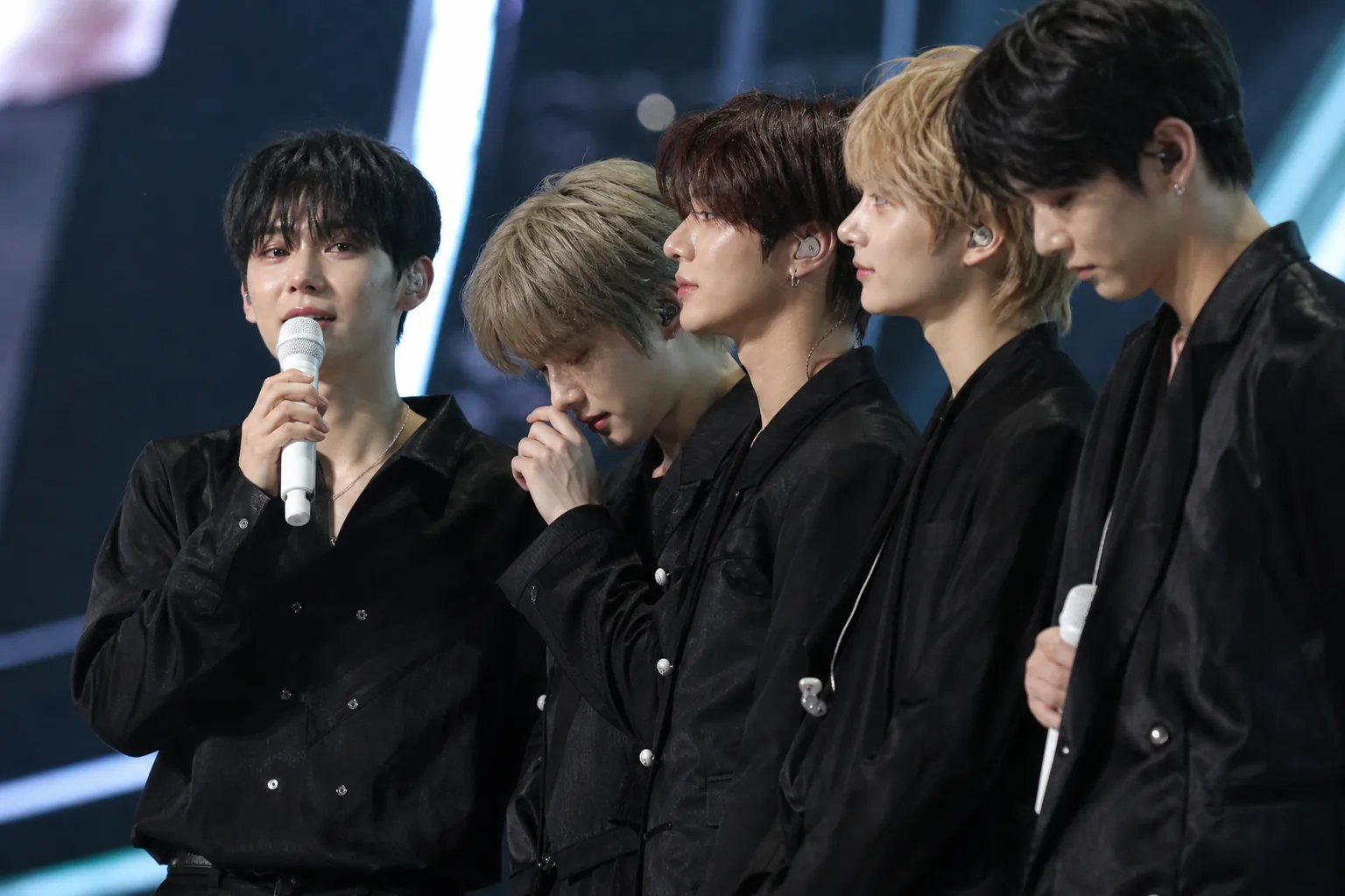 Fans discussing K-pop live vocals on phones after an award show