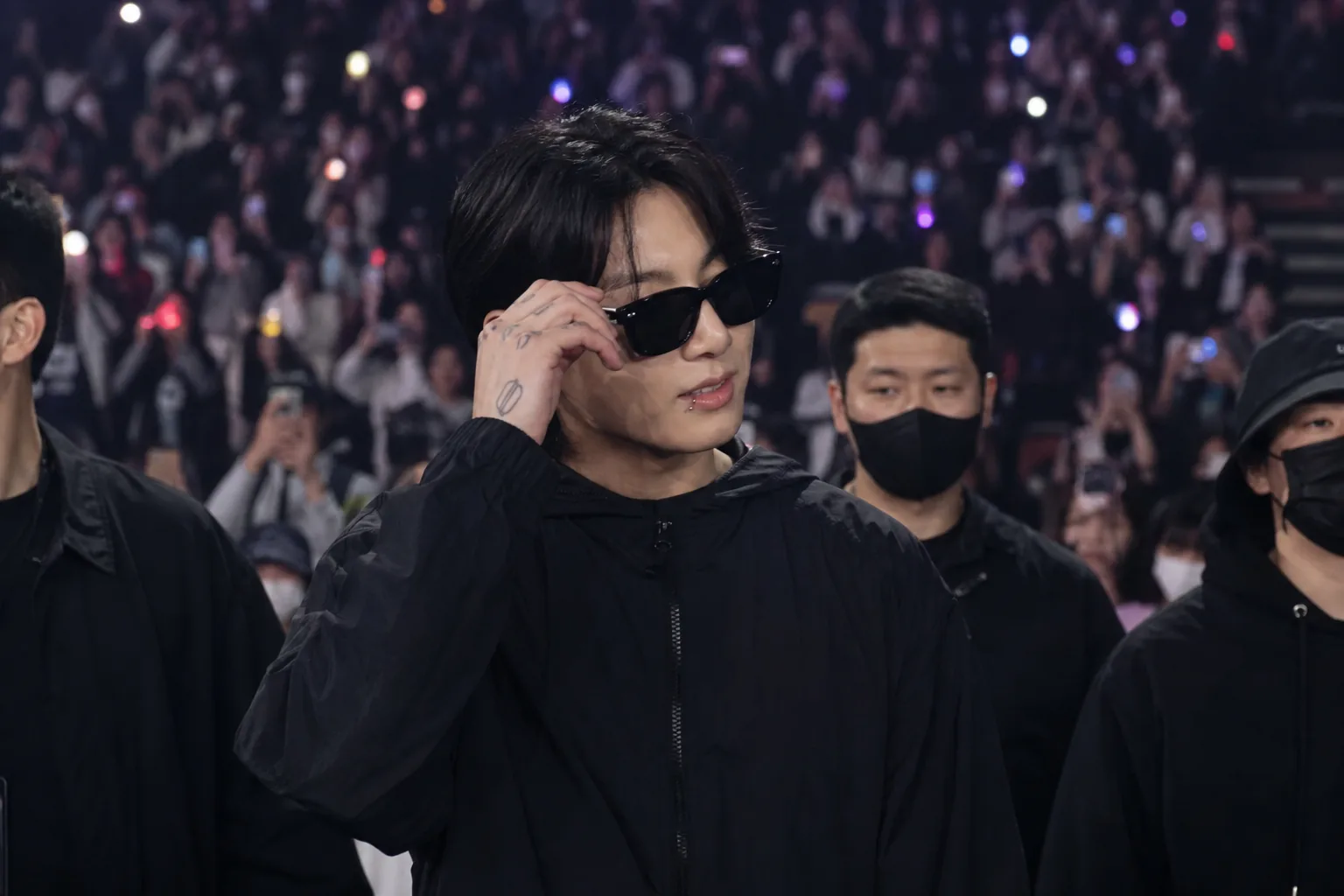 Fans at a K-pop concert reacting to a surprise celebrity appearance in the audience