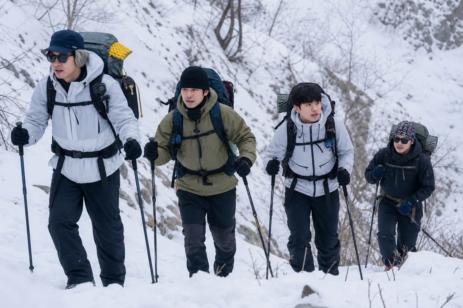 Cast members hiking through a snowy mountain for a Korean variety show