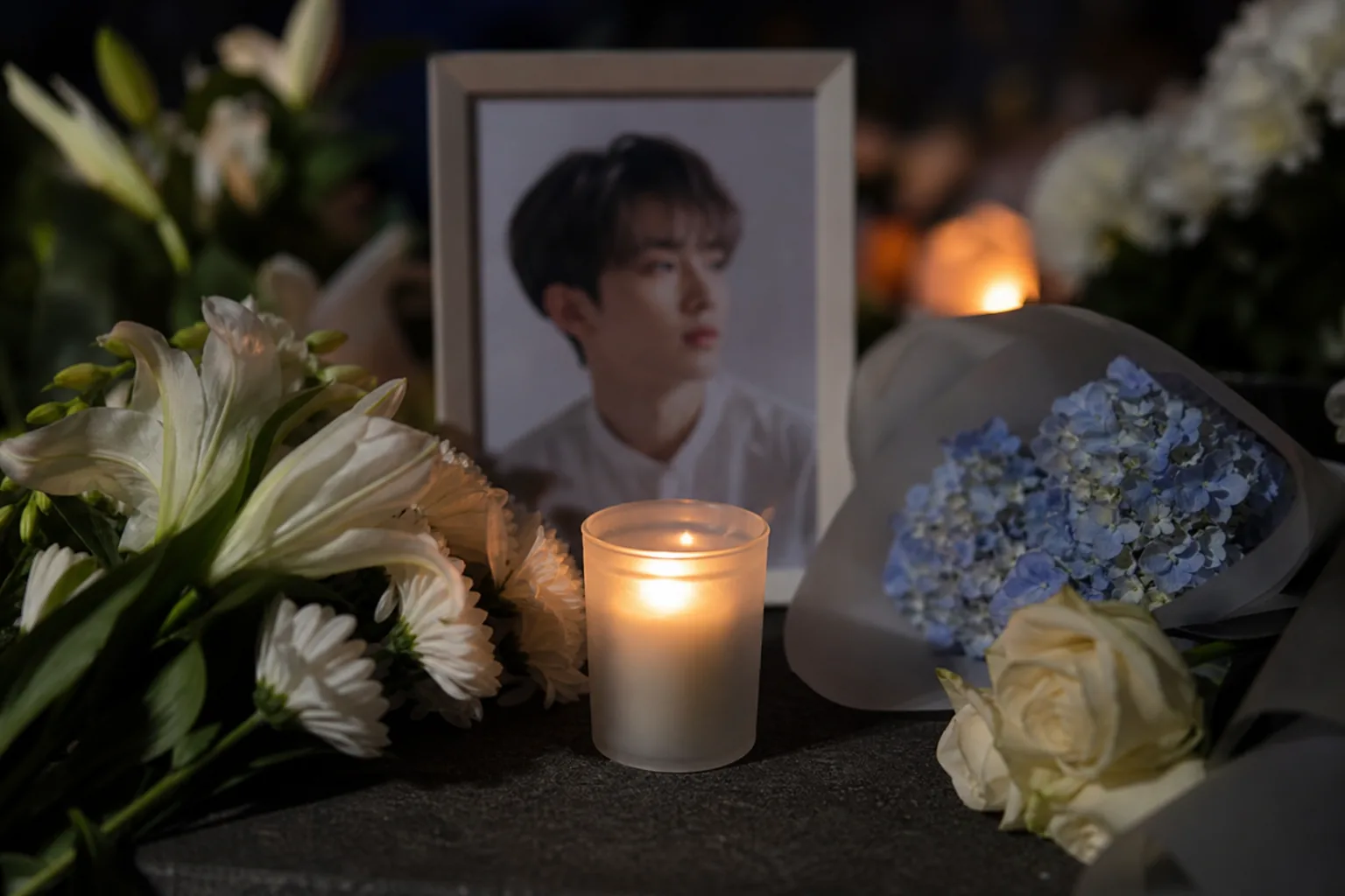 Empty concert spotlight symbolizing a tribute to late Spectrum member Kim Dongyoon