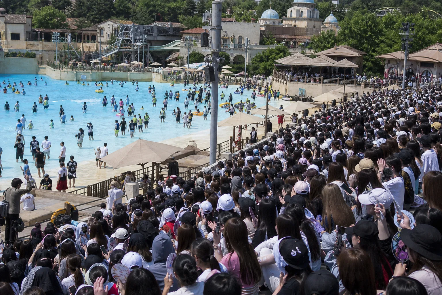 Event staff monitoring a crowded outdoor water park performance area