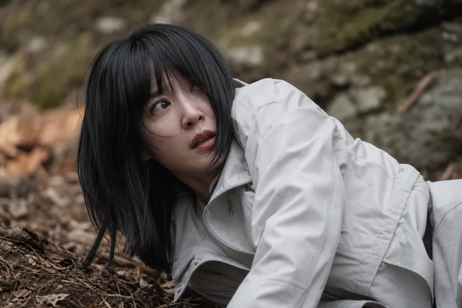 Tense thriller scene showing a woman confronting danger in a remote forest