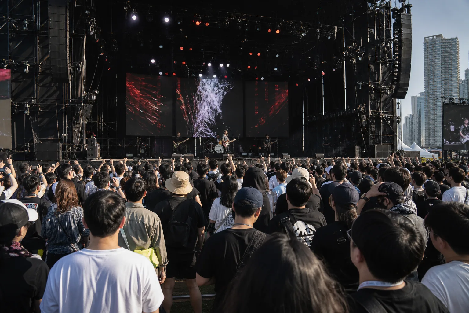 Festivalgoers watching an evening live band performance under stage lights