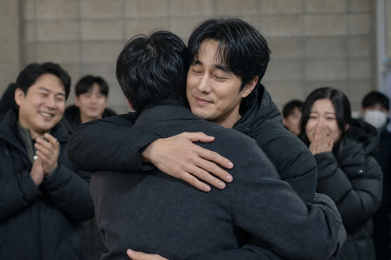K-drama cast members exchanging farewell hugs at a production wrap