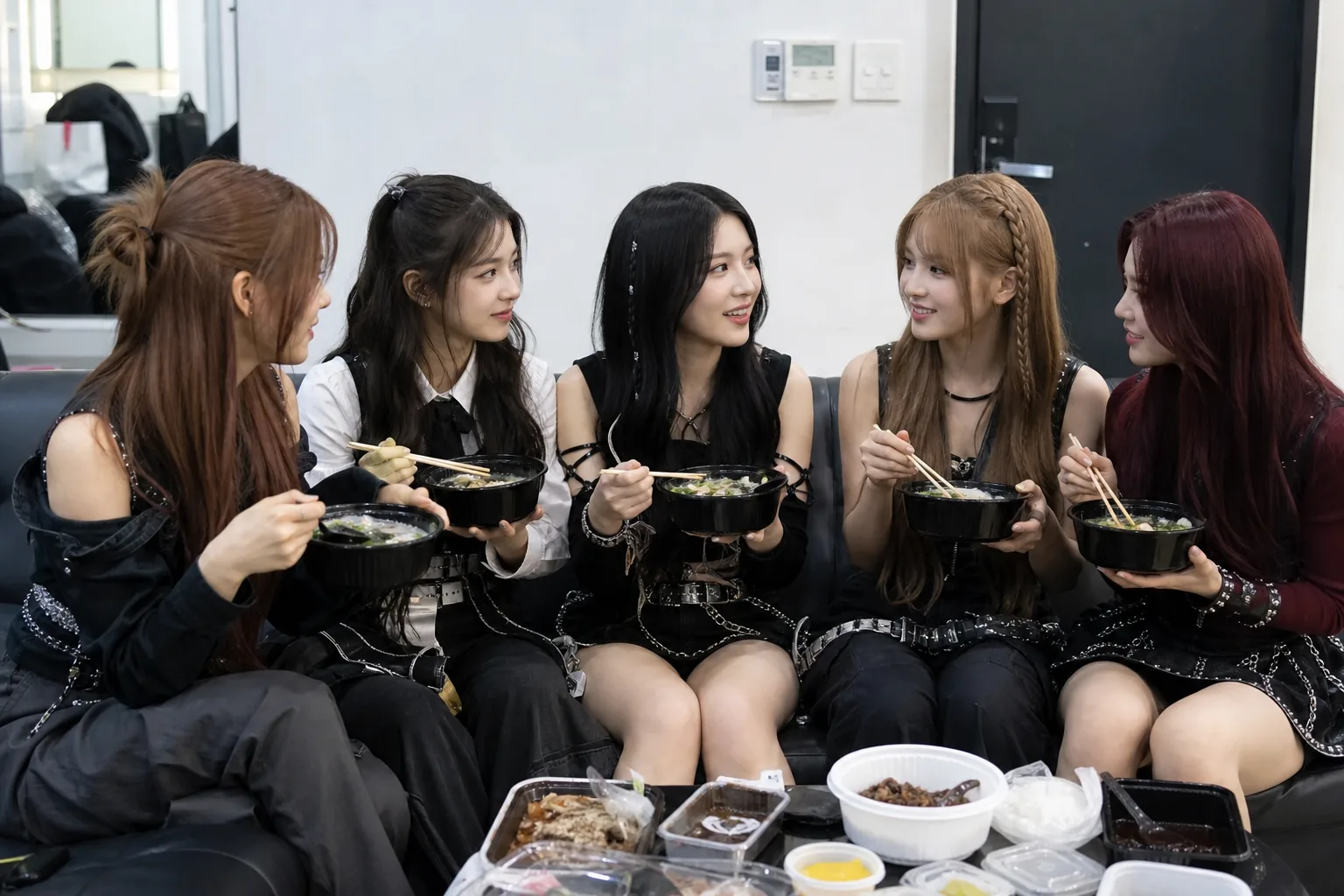 K-pop artists and staff discussing future plans in a television production setting