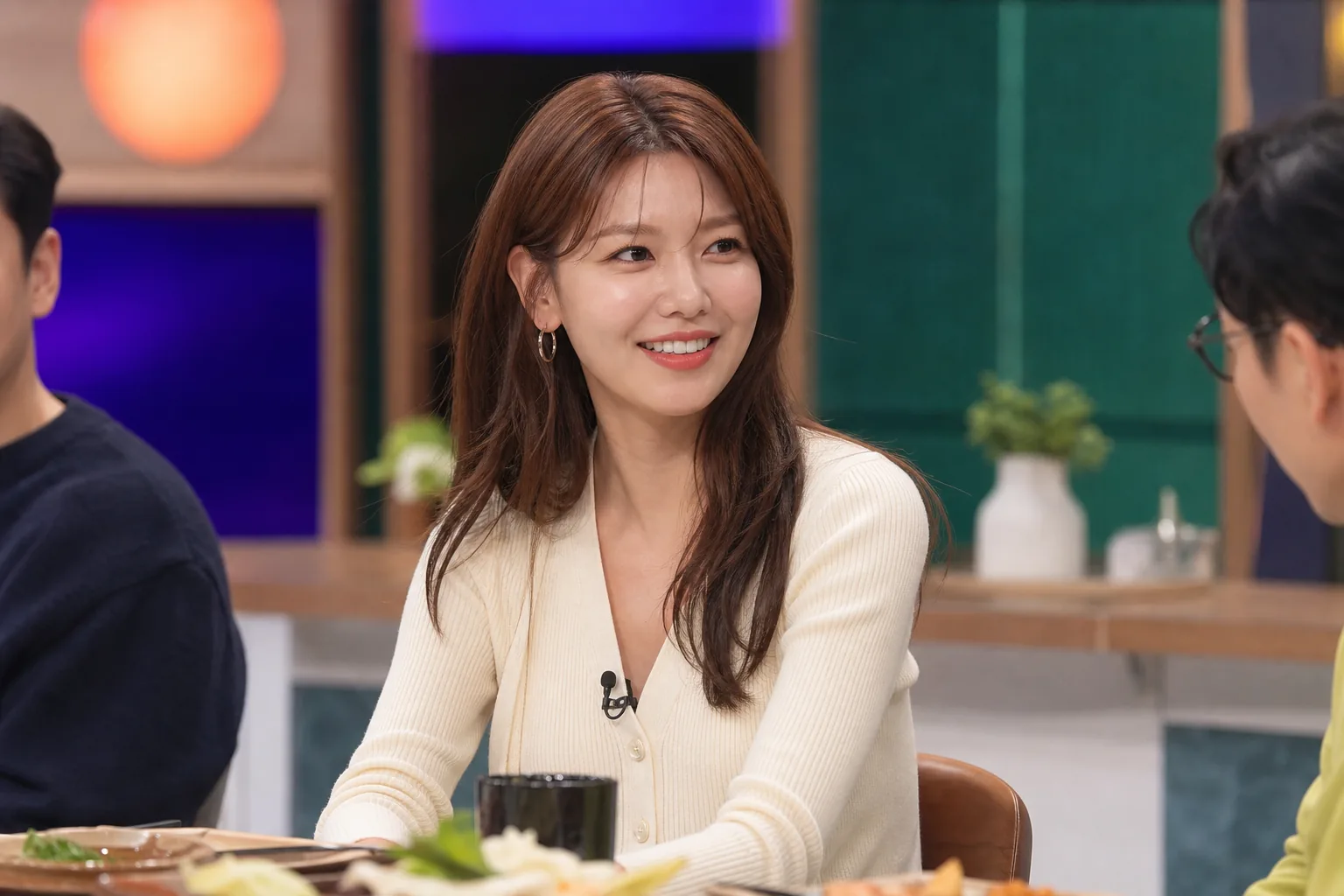 Bright Korean variety show kitchen set with a dining table and studio lights