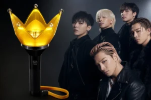 Concert crowd holding glowing crown-shaped K-pop light sticks