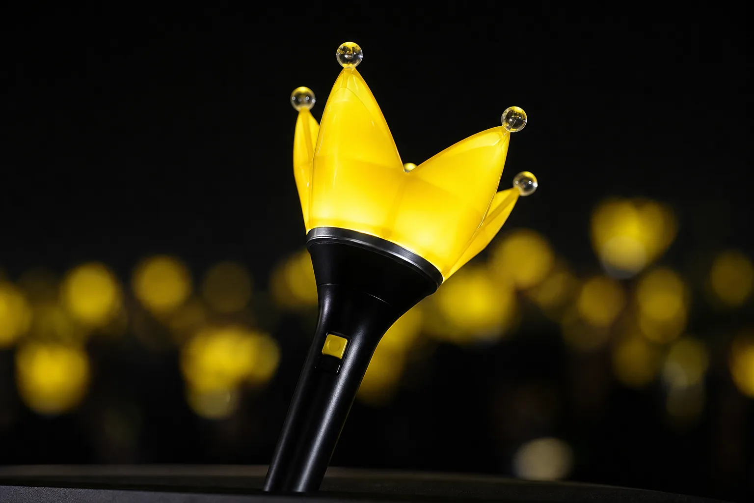 Close-up of a modern glowing K-pop concert light stick in a dark arena