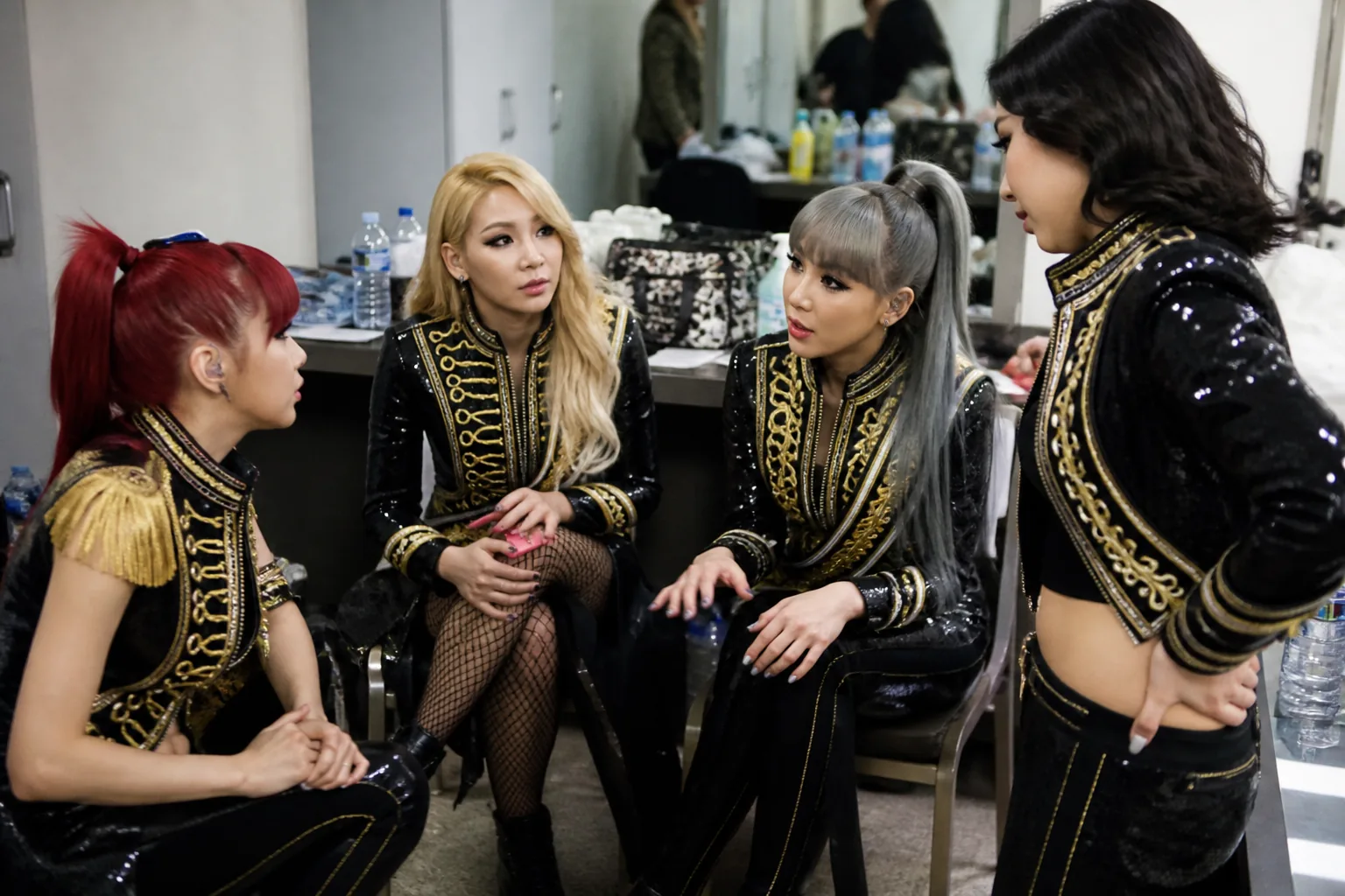 K-pop performers preparing together in a backstage dressing room