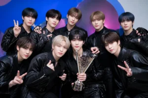 K-pop group celebrating a first music show trophy on stage