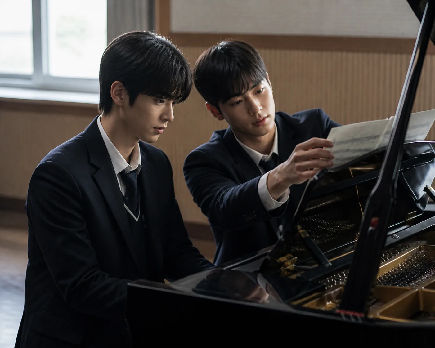 Two student pianists sharing a piano bench during an arts school rehearsal