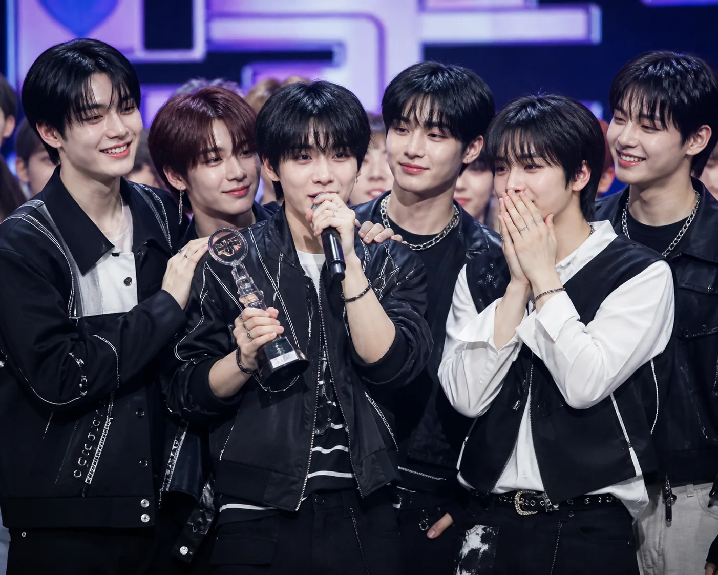 K-pop boy group celebrating a music show win on stage