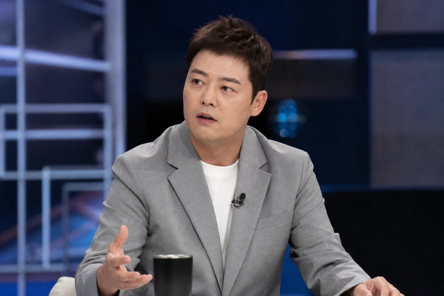 Warmly lit Korean talk show set prepared for a serious conversation