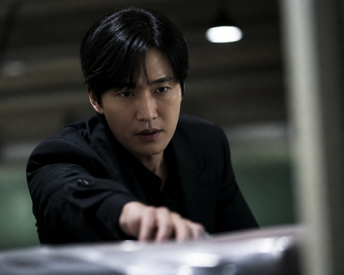 A tense Korean crime thriller confrontation in a dimly lit interior