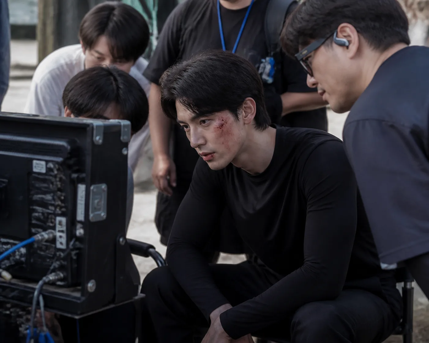 Korean action drama actor reviewing a filmed scene on set