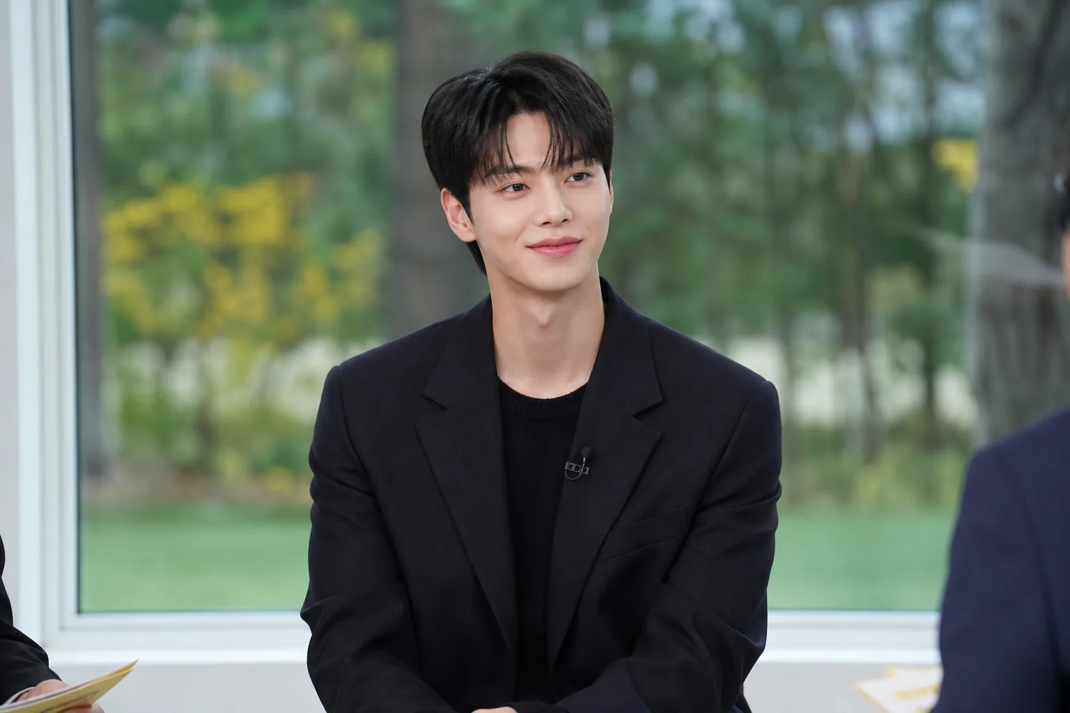 Guest preparing for a seated conversation in a Korean television studio
