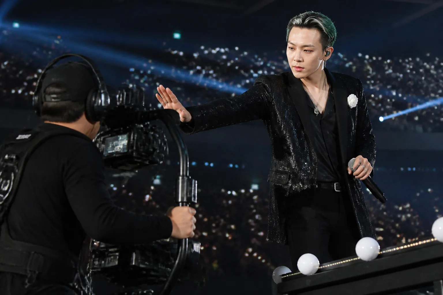 대형 콘서트 무대에서 공연자와 함께 작업하는 카메라팀
