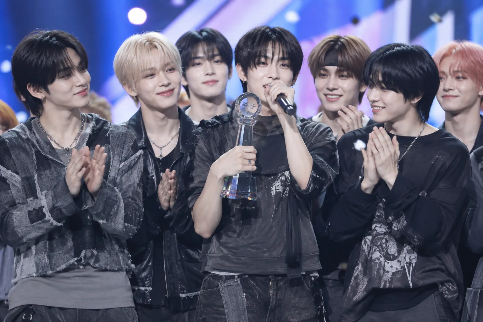 TV 앙코르 무대에서 트로피를 들고 축하하는 K팝 퍼포머들